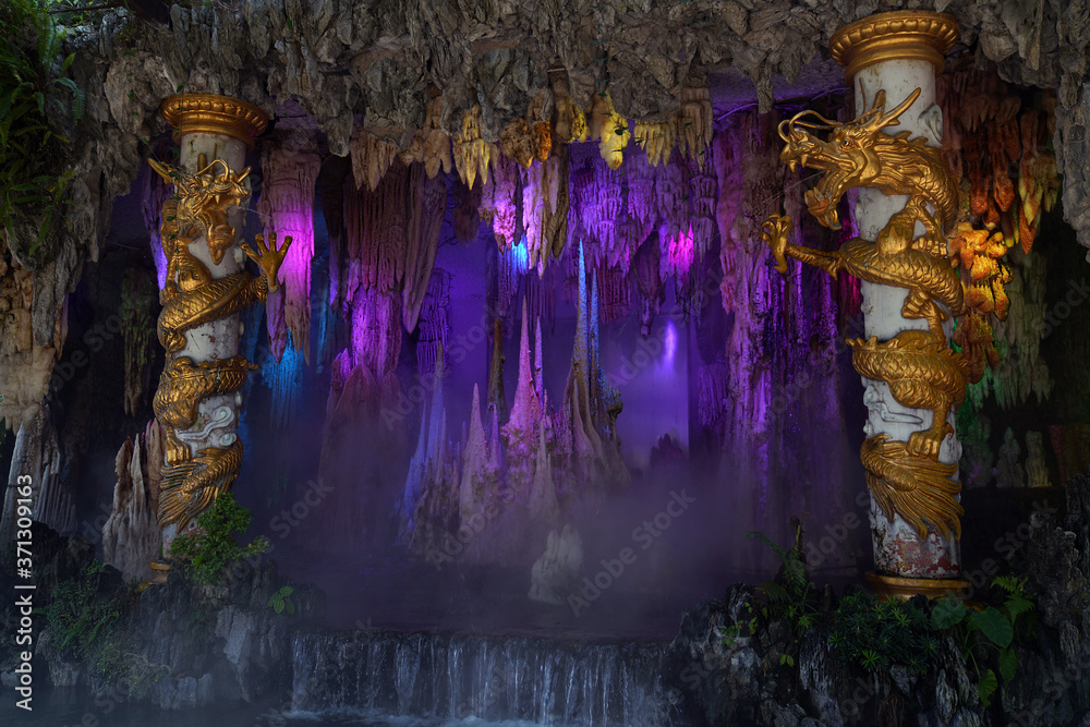 decorative cave with white columns and golden dragons and waterfall in Baomo Park, Guangzhou