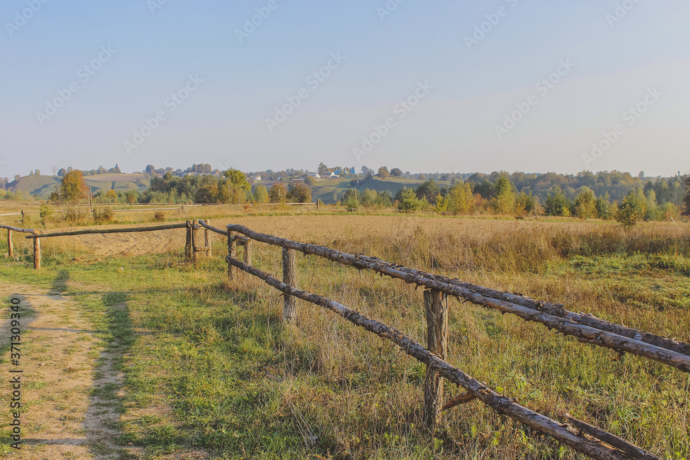 path in the field. wooden rustic fence path in the field. wooden rustic fence