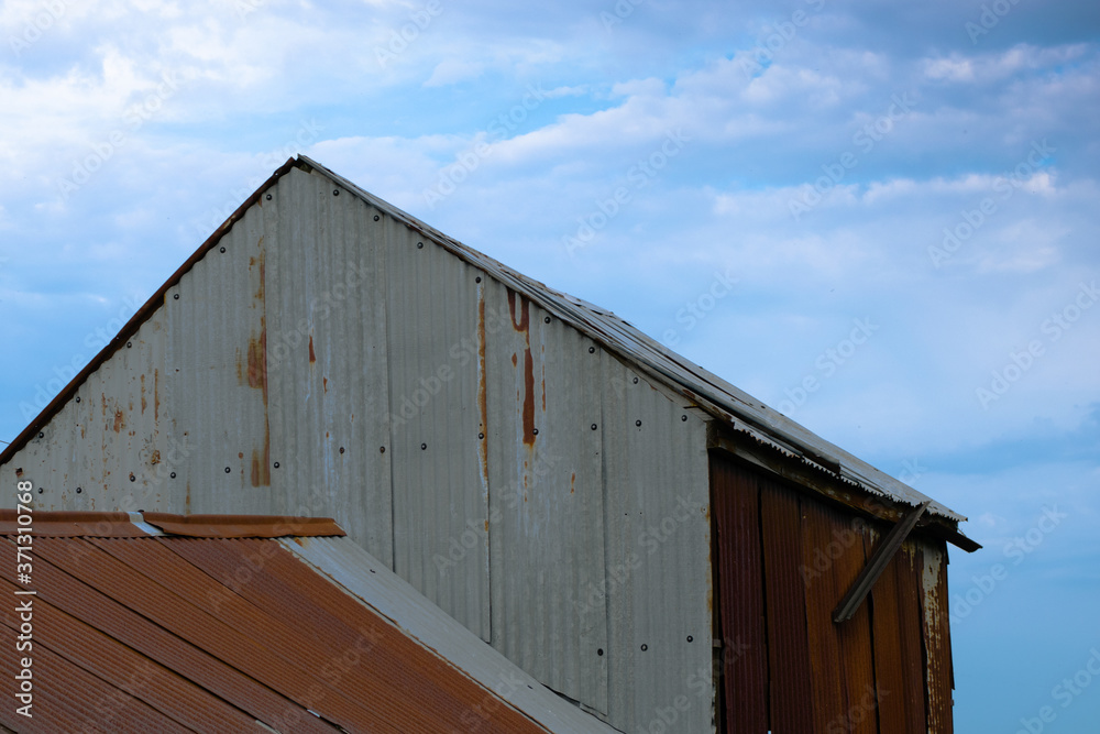 Corrugated iron farm building with red roof Corrugated iron farm building with red roof