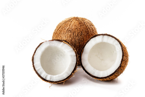 Coconut on a black background. Chopped coconut. Several parts. Stone surface. Fresh coconut. White pulp.