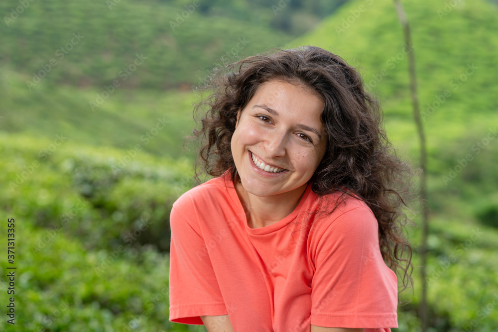 Beautiful brunette girl posing in the middle of the tea valley between green tea bushes. Beautiful brunette girl posing in the middle of the tea valley between green tea bushes.