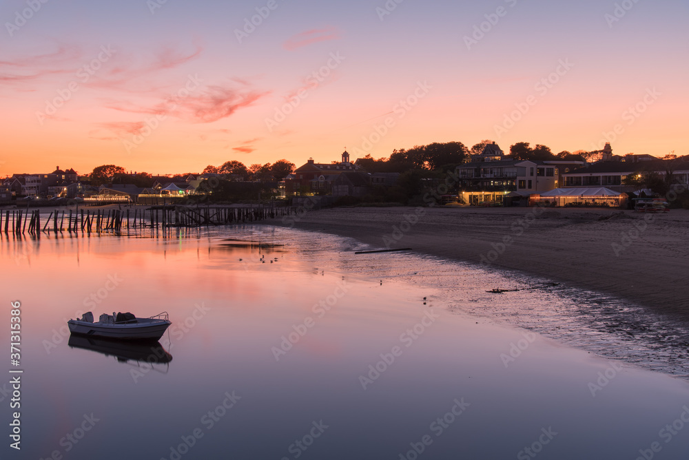 Deserted sandy beach at dusk. An anchored boat is visible in foreground. Long exposure. Provincetown, Cape Cod, MA, USA.