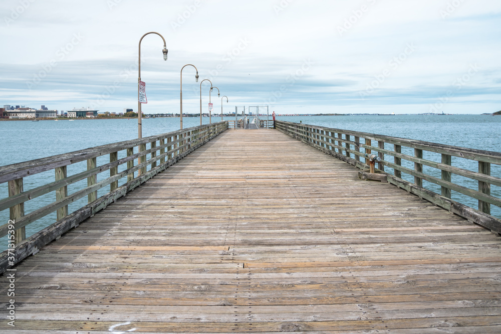 Deserted  weathered pier on a cloudy autumn day. Boston, MA, USA.