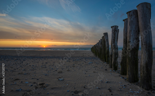 Wooden fence on the beach of Calais at sunset.