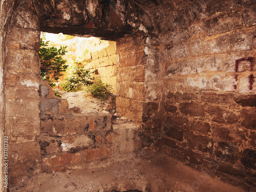 Mystic interior of an ancient dungeon. An old abandoned tunnel in an underground wine cellar. Entrance to catacombs. Dungeon An old stone fortress. As creative background for staging dark design.