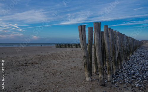 Wooden fence on the beach of Calais at sunset.