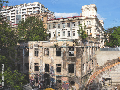 Odessa, Ukraine - May 17, 2017: Panoramic view of street with decaying houses in a poor neighborhood. Ruined building after a natural disaster. Provide shelter for homeless people and drug addicts. © Elena