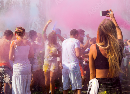 ODESSA, UKRAINE - August 5, 2017: Young people, boys and girls have fun during Holi holiday, throwing colorful powder into each other. Festival of Colored Paint, of colors love in Odessa. Color fest