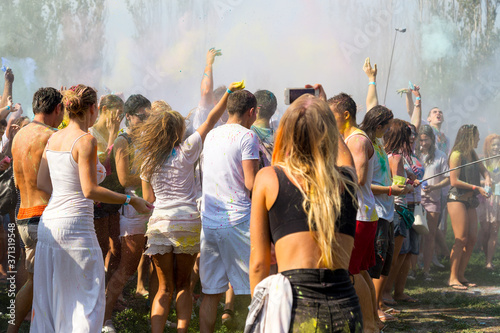 ODESSA, UKRAINE - August 5, 2017: Young people, boys and girls have fun during Holi holiday, throwing colorful powder into each other. Festival of Colored Paint, of colors love in Odessa. Color fest