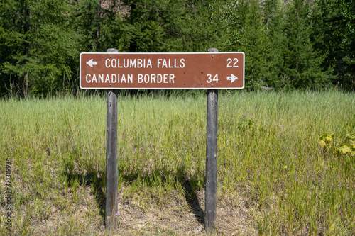 SIgn along North Fork Road in Glacier National Park - Columbia Falls and the Canadian Border mileage sign in Montana