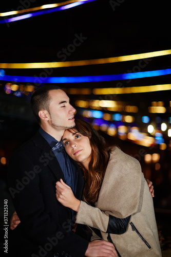 Portrait of cute young couple sharing a tender hug while out on a date