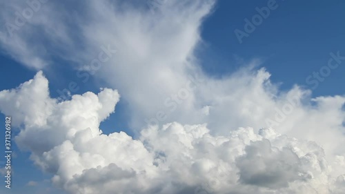White cumulus clouds on a blue sky. Time Lapse.