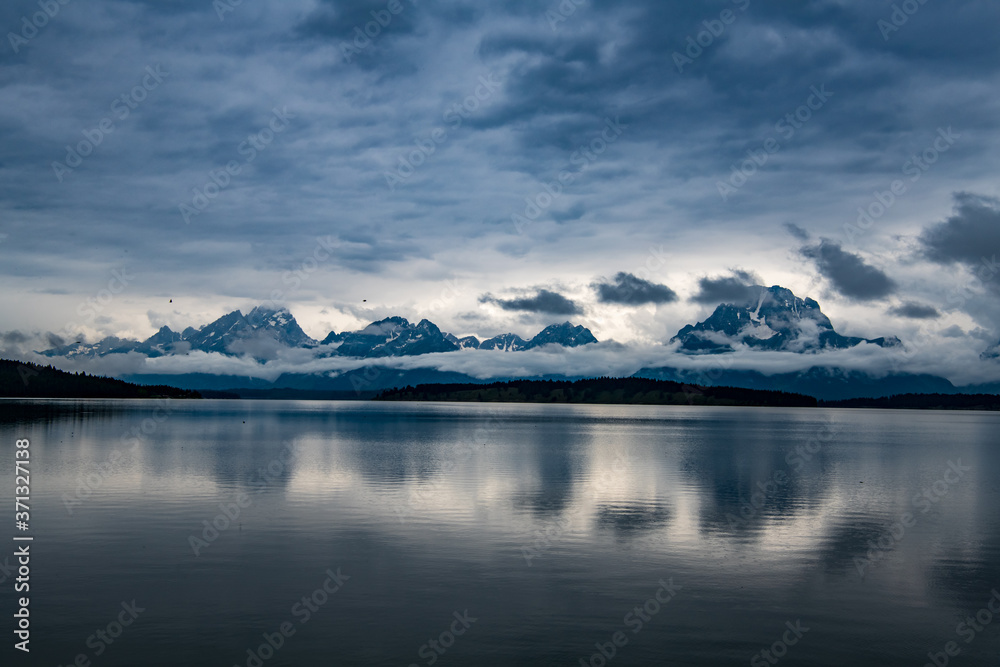 Jackson Lake is in Grand Teton National Park in northwestern Wyoming. The photo was taken while low lying clouds were surrounding the mountains and reflecting onto the lake