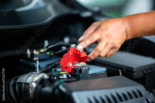 Selective focus to check and maintenance the battery in car with yourself. Service and maintenance car or vehicle.