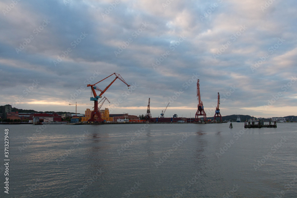 Gothenburg, Sweden - June 17 2019: the view of cranes in Gothenburg harbour at sunset light on June 17 2019 in Gothenburg, Sweden.