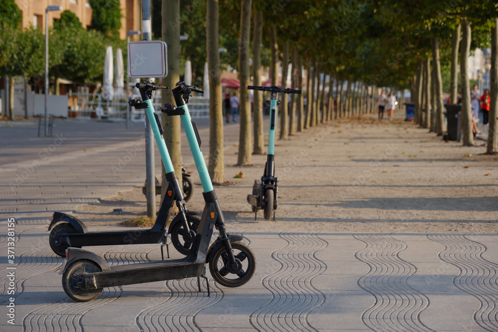 Group of parking E-scooters by startup company with Eco friendly mobility concept of sharing Electric Scooter park on promenade riverside of Rhine River in Düsseldorf, Germany.
