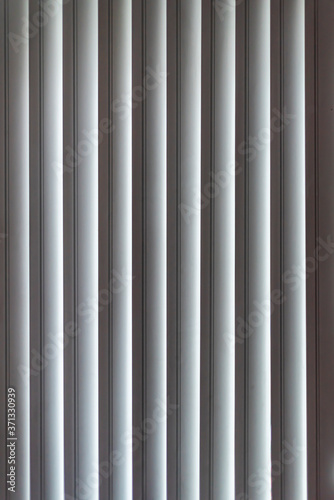Vertical window blinds. Real blind curtains. Striped background with silver jalousie