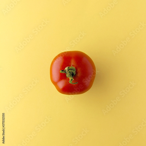 Simple tomato on yellow background