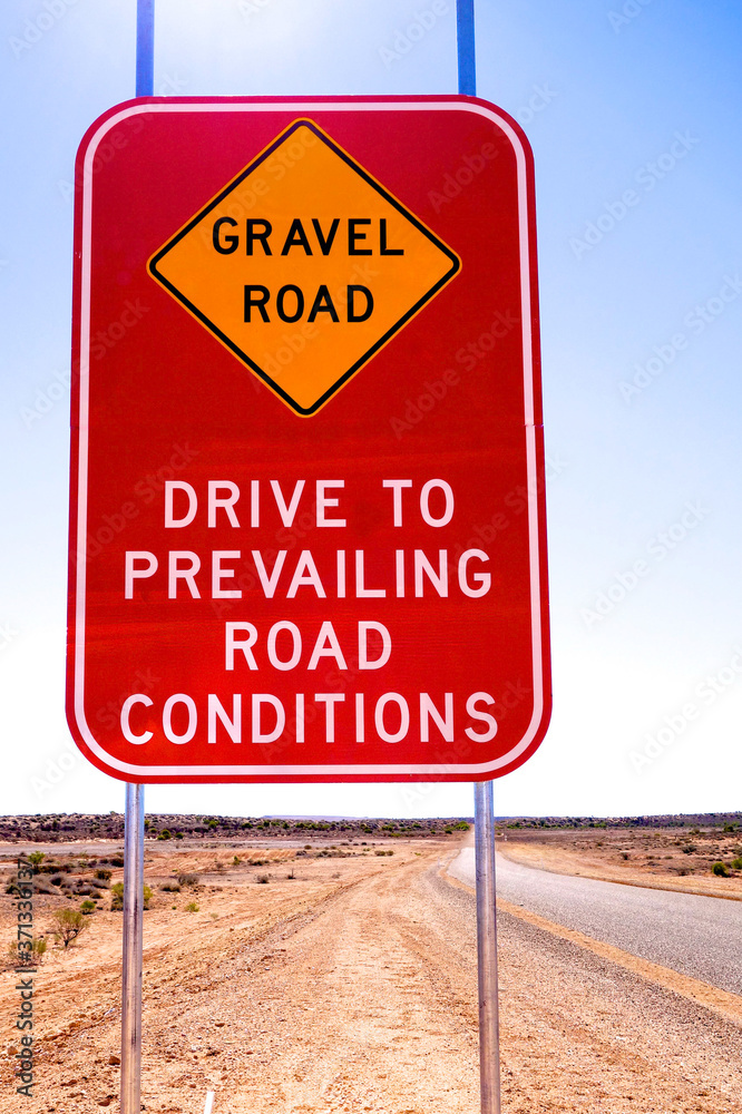 Gravel Road sign warning drivers to drive to prevailing road conditions