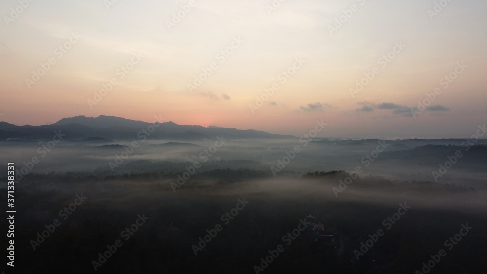 Fototapeta premium Aerial view of sunrise with light mist. Mount Ireng Gunungkidul Yogyakarta