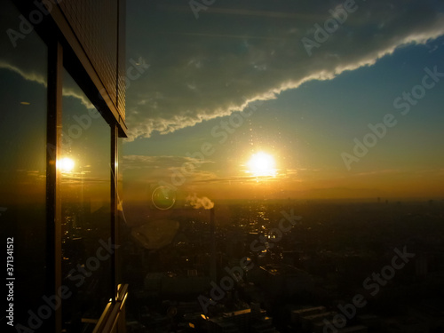 The sun of the orange reflecting in the wall surface of the building