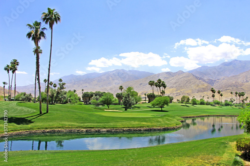 Green oasis in the desert - Golf course with palm trees and pond / river in Palm Spring. © Klara