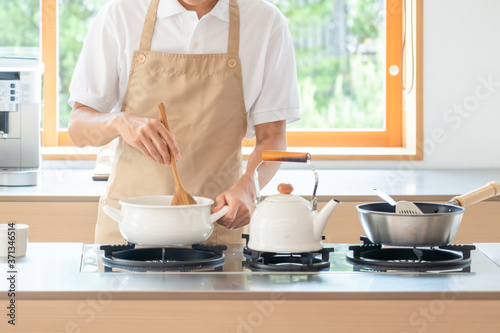 キッチンで料理する若い男性