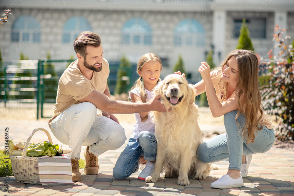 Young family stroking their pet and looking peaceful