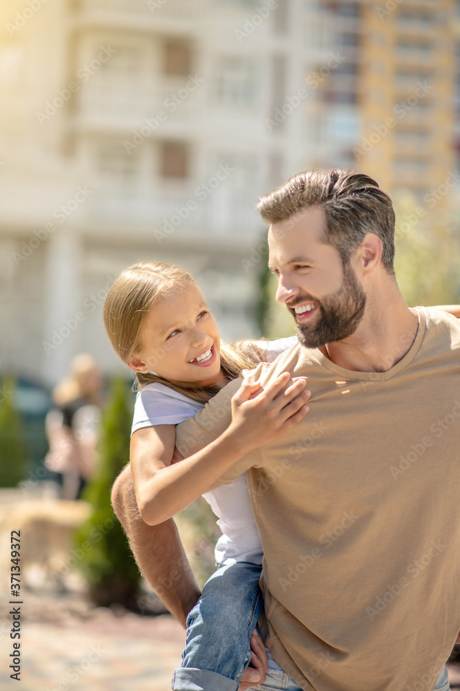 Fototapeta premium Dad holding his cute daughter and smiling