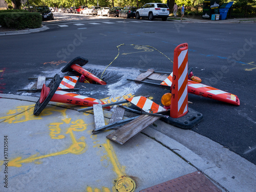 Fotografi cordoned off pothole in city street with caution cones knocked over waiting for