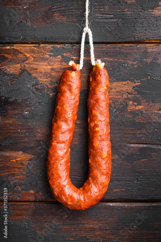 Traditional spanish chorizo sausage on old wooden table, topview