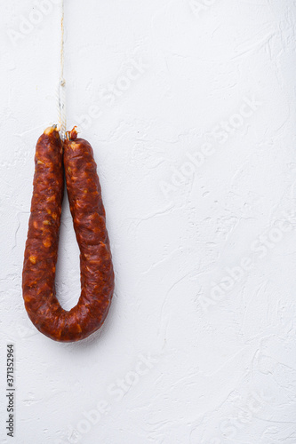 Spanish chorizo sausage on white textured background with copy space