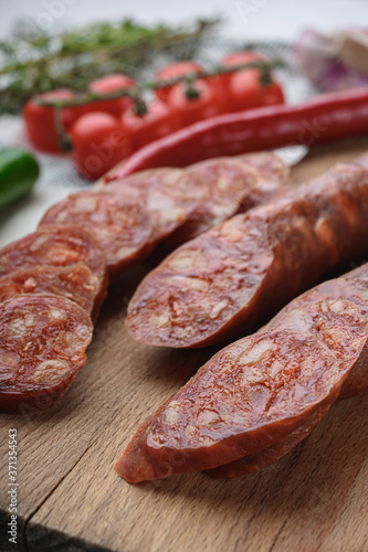 Traditional chorizo cuts with spices and ingredients on white surface