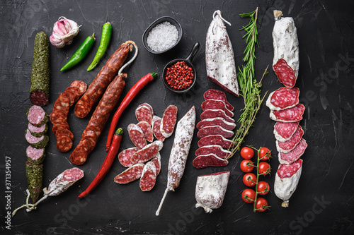 Fotografie, Obraz Set of various spanish dry cured salami sausages slices and whole cuts on balck