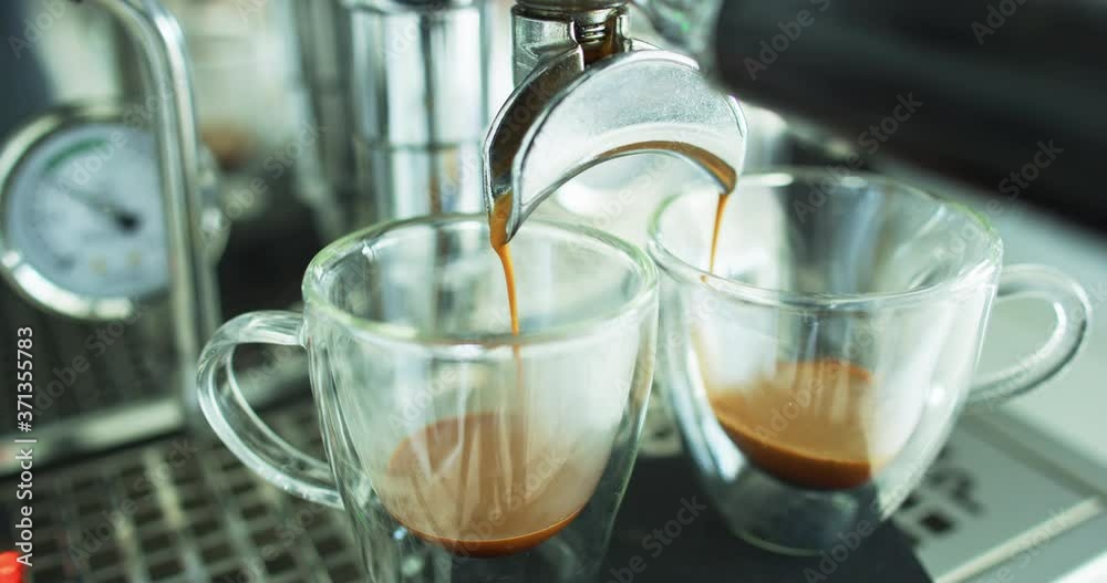 Espresso coffee. Making espresso coffee pouring shots on using 2 spout portafilter on espresso machine Professional equipment at home or at cafe coffee shop.