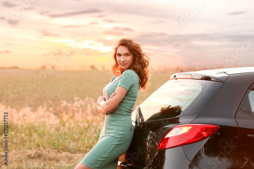 Young woman near car in countryside photo