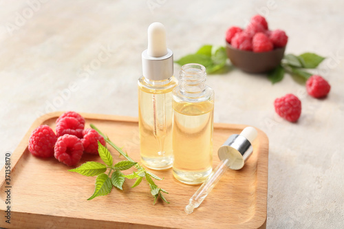 Bottles of raspberry essential oil on table