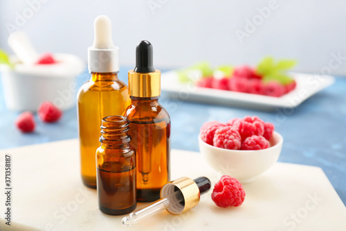 Bottles of raspberry essential oil on table