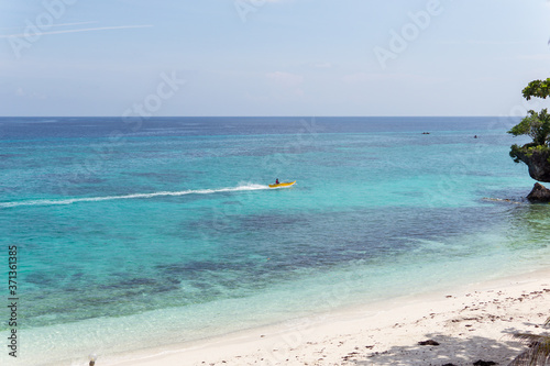 Obraz na płótnie Unrecognizable Filipino man on small catamaran on paradise beach with turquoise water and white sand in Philippines w salonie