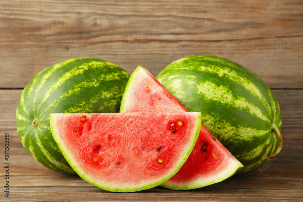 Fresh watermelon and slice on grey wooden background. Fresh watermelon and slice on grey wooden background.