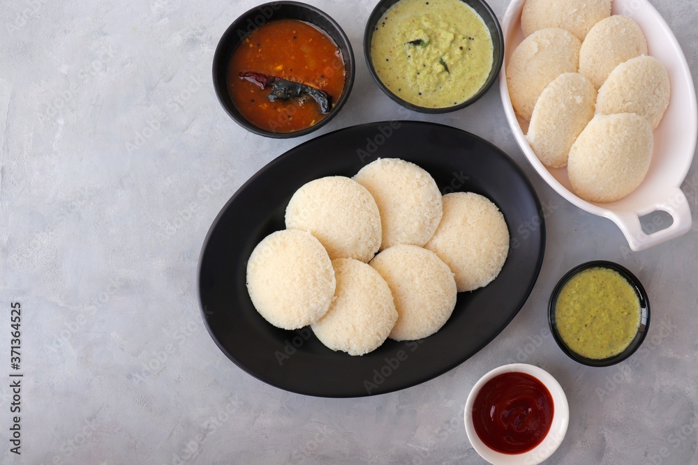 Fototapeta premium South Indian breakfast dish Idli with Coconut Chutney and sambar. Idly sambar. over light background with copy space.