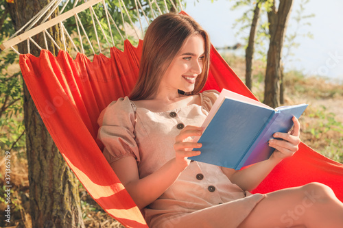Young woman reading book wh...
