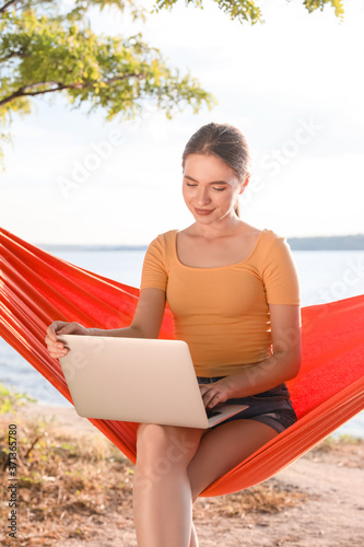 Young woman with laptop rel...