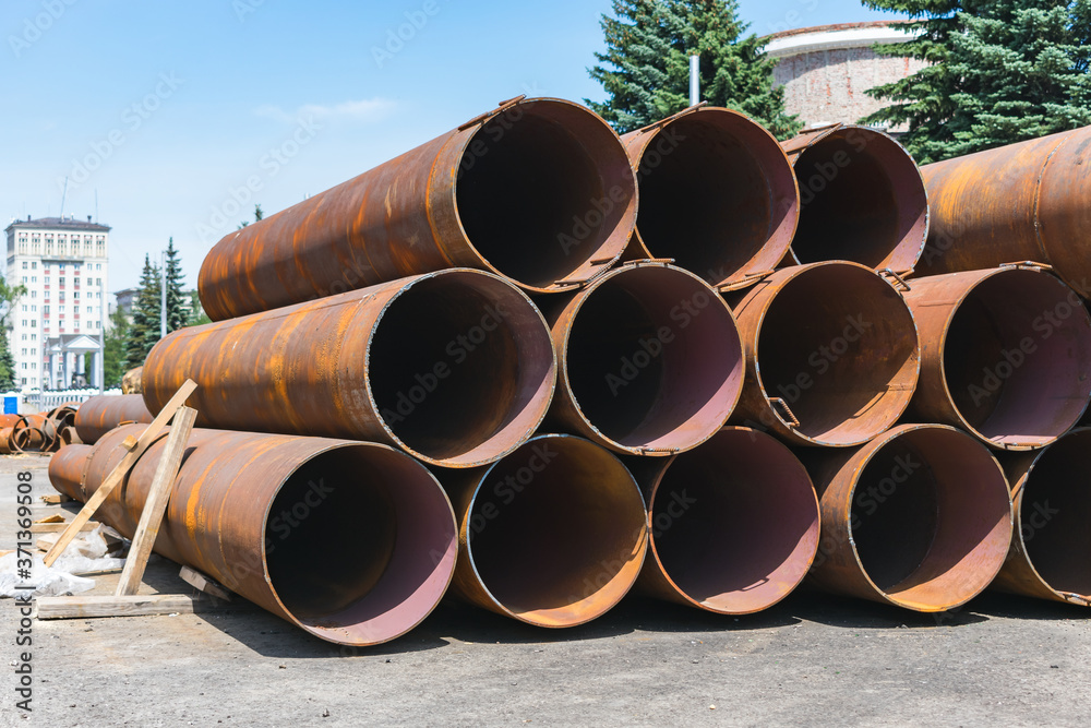 Large, old and rusty sewer pipes stacked in one batch for recycling Large, old and rusty sewer pipes stacked in one batch for recycling