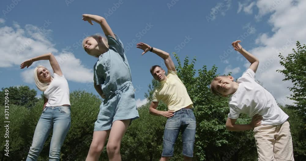 Wellness, family outdoor recreation, parents and their kids are engaged in fitness activities in the city Park. Wellness, family outdoor recreation, parents and their kids are engaged in fitness activities in the city Park.