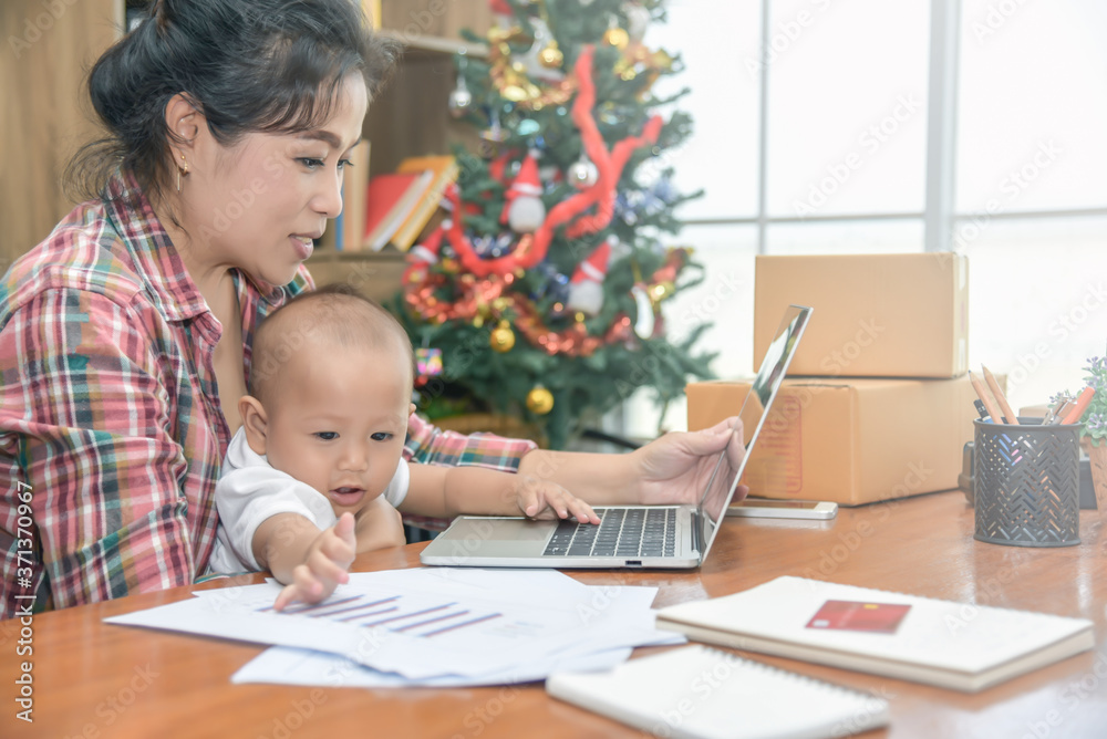 Young Asian beautiful women working at home, and take care of daughter. Baby girl sitting with mother and playing mother laptop. Work at home. Young Asian beautiful women working at home, and take care of daughter. Baby girl sitting with mother and playing mother laptop. Work at home.