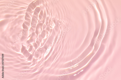 Fotografia Closeup of pink transparent clear calm water surface texture with splashes and bubbles