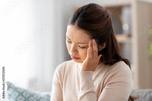 Fotografia people and health problem concept - sick asian woman having headache at home
