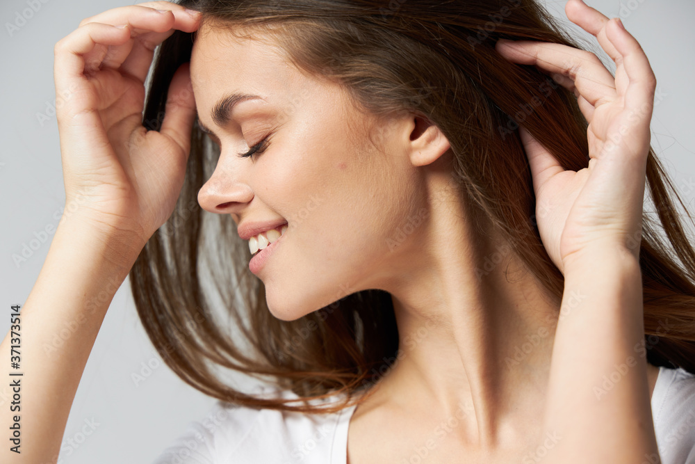 Fototapeta premium Cute woman closed eyes holding hair in hands