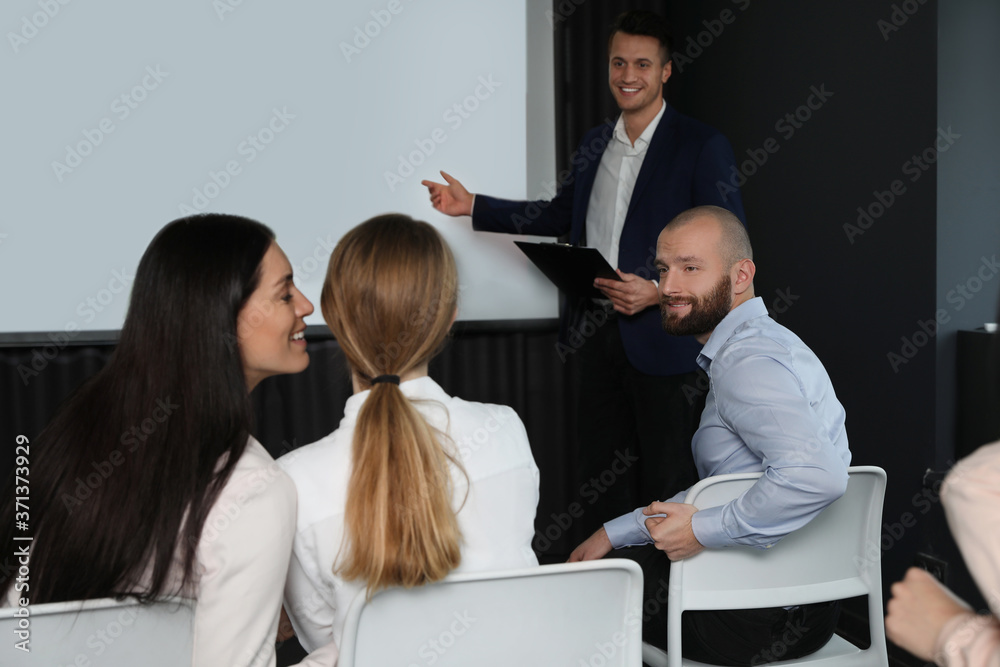 Business people at seminar in conference room with video projection screen Business people at seminar in conference room with video projection screen